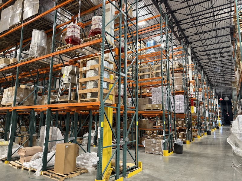 Interior shot of a MoreWine! Pro warehouse with tall, stocked aisles